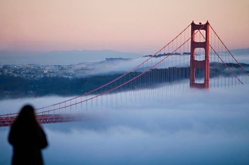 Woman Looking Out At Bridge Fog